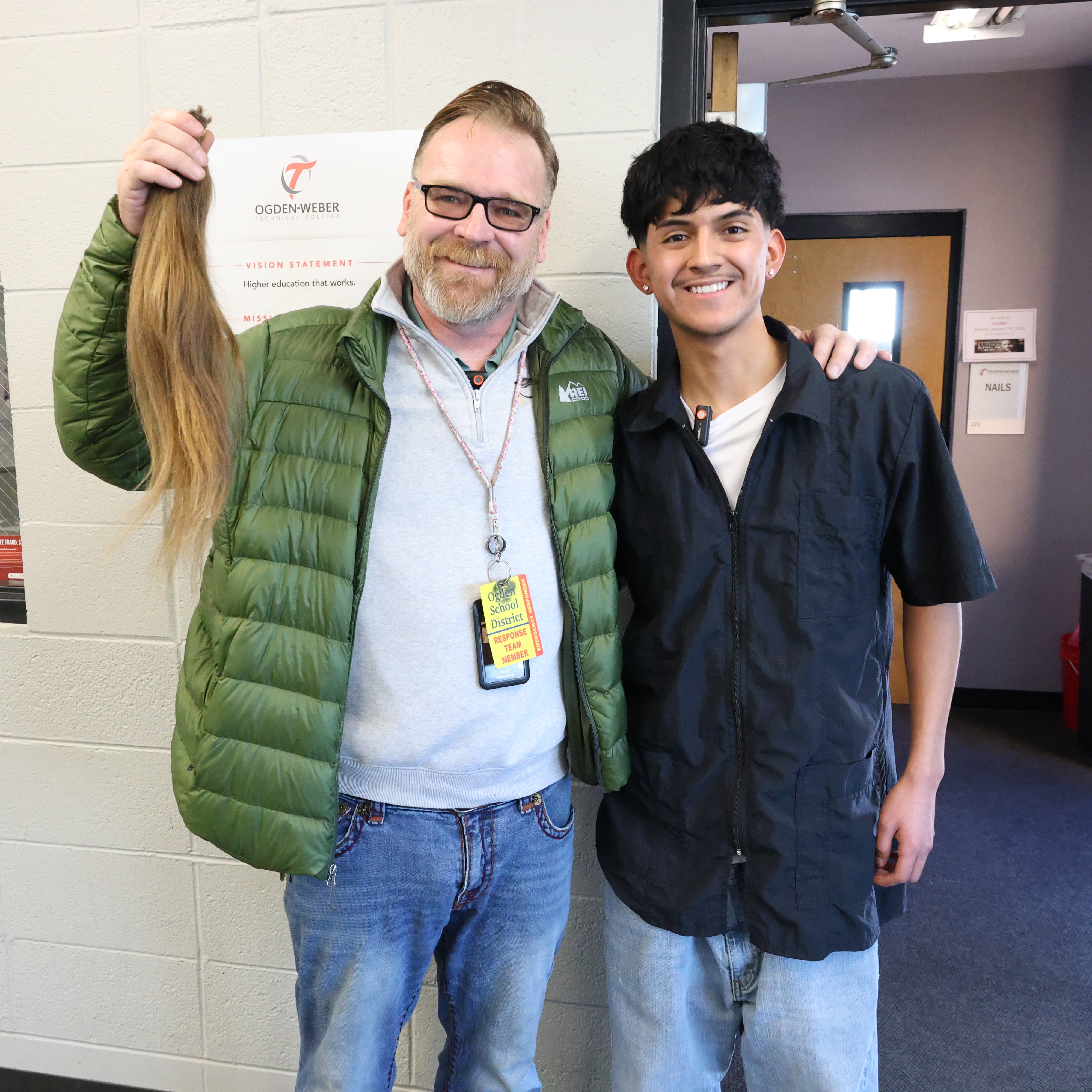 Staff holding his hair after student cut his hair 