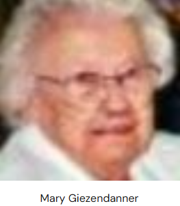 An elderly woman with light, wavy hair wearing a white top. The image includes the name "Mary Giezendanner" below.