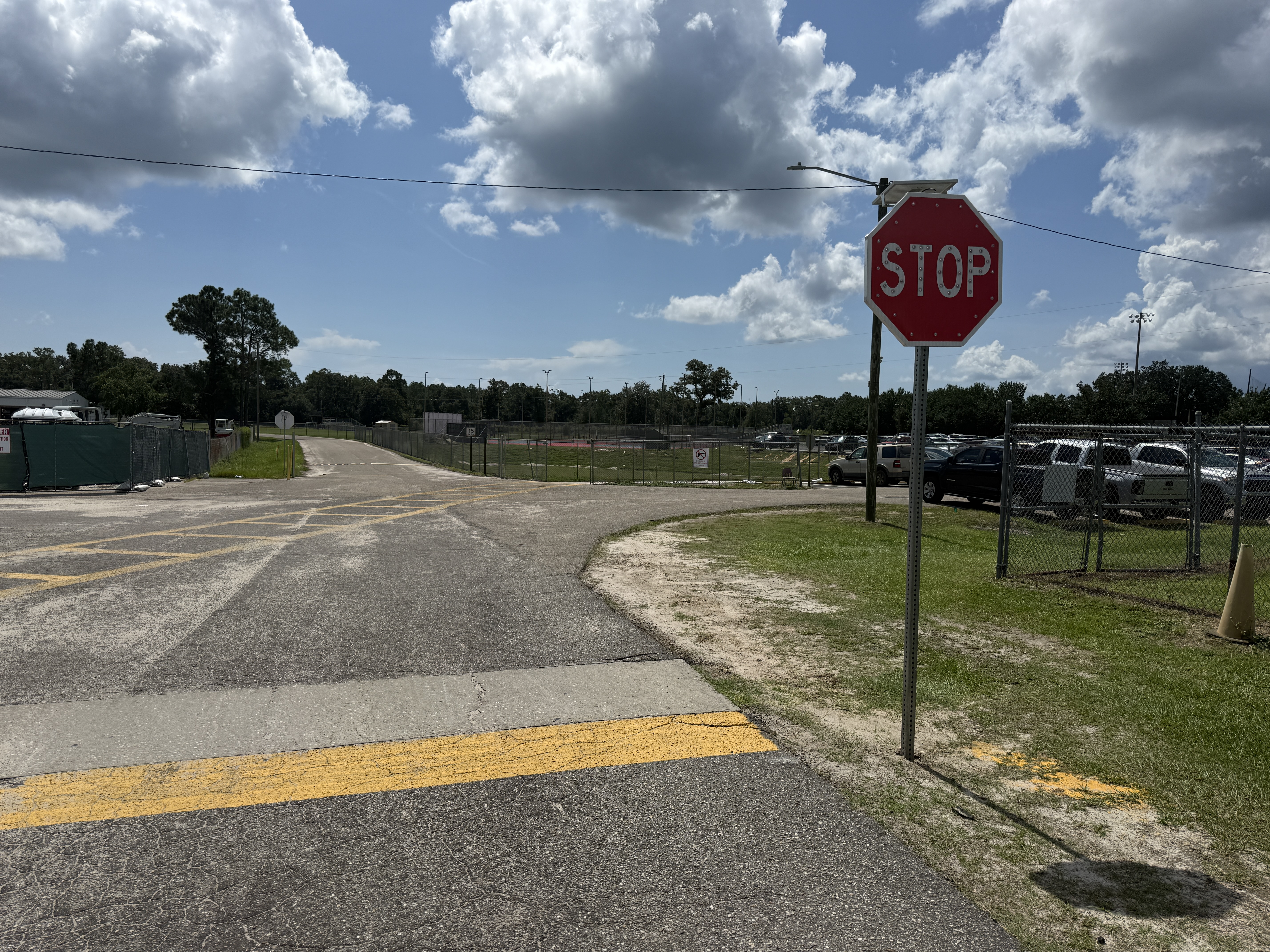 Wide view of the new stop sign outside the student parking area.