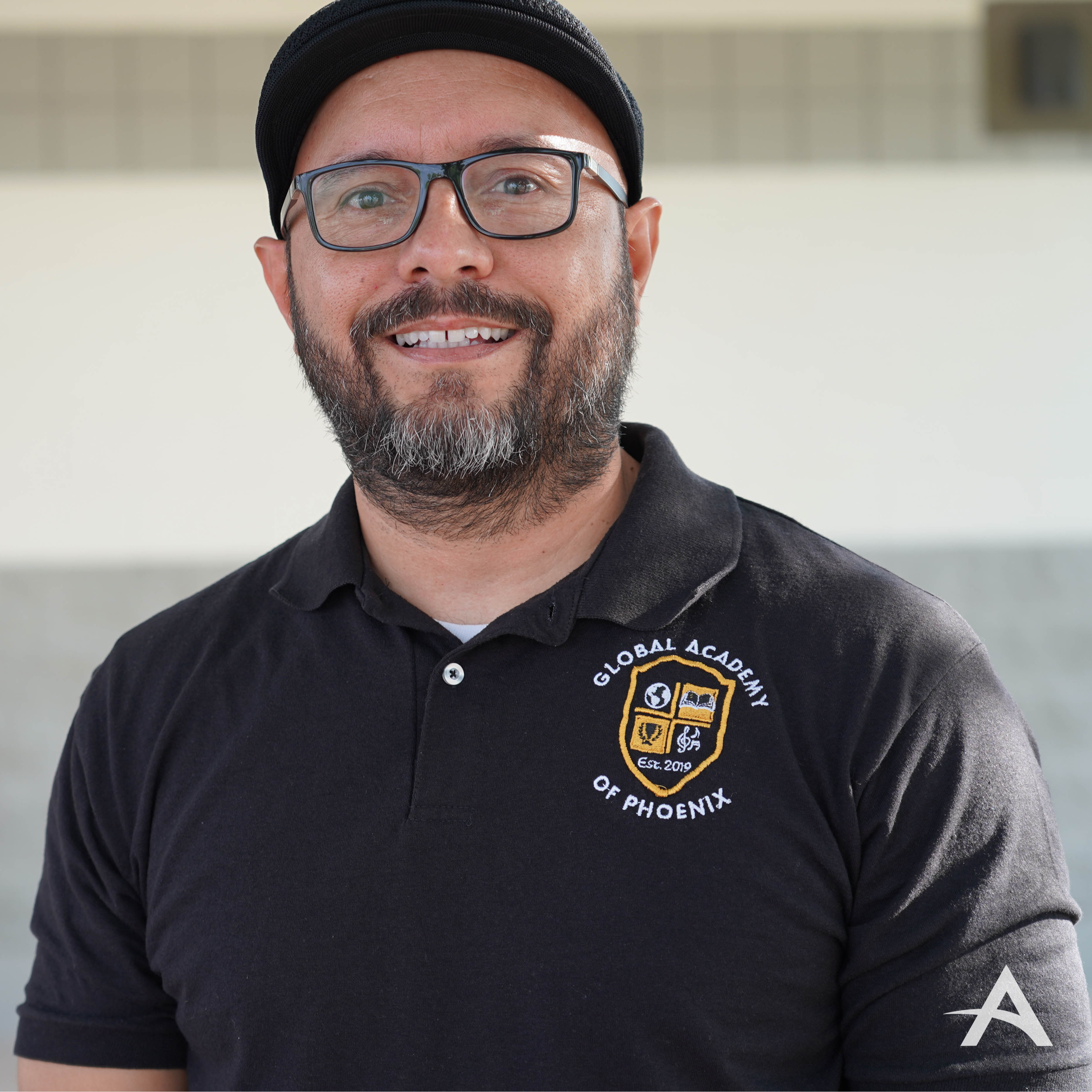 Smiling man in black top and black hat