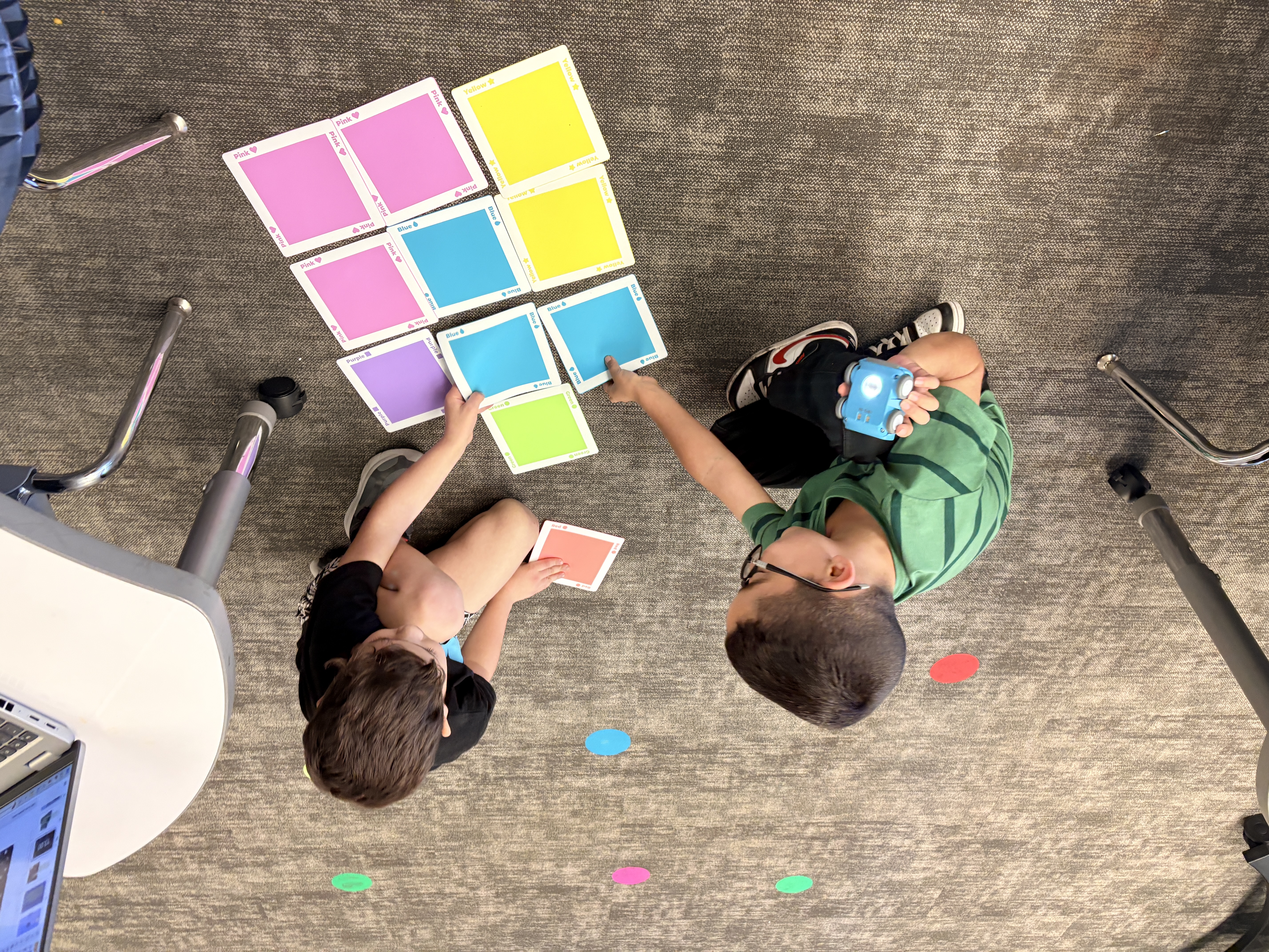 Two students playing with an INDI robot at Robertson Elementary in Round Rock Texas