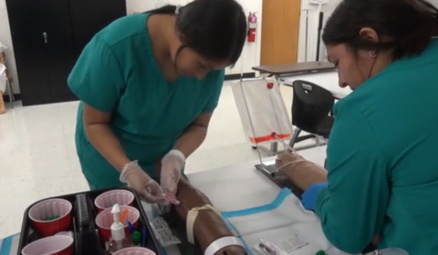 Two nurses attending to a patient in a hospital, demonstrating teamwork and care in a medical setting.