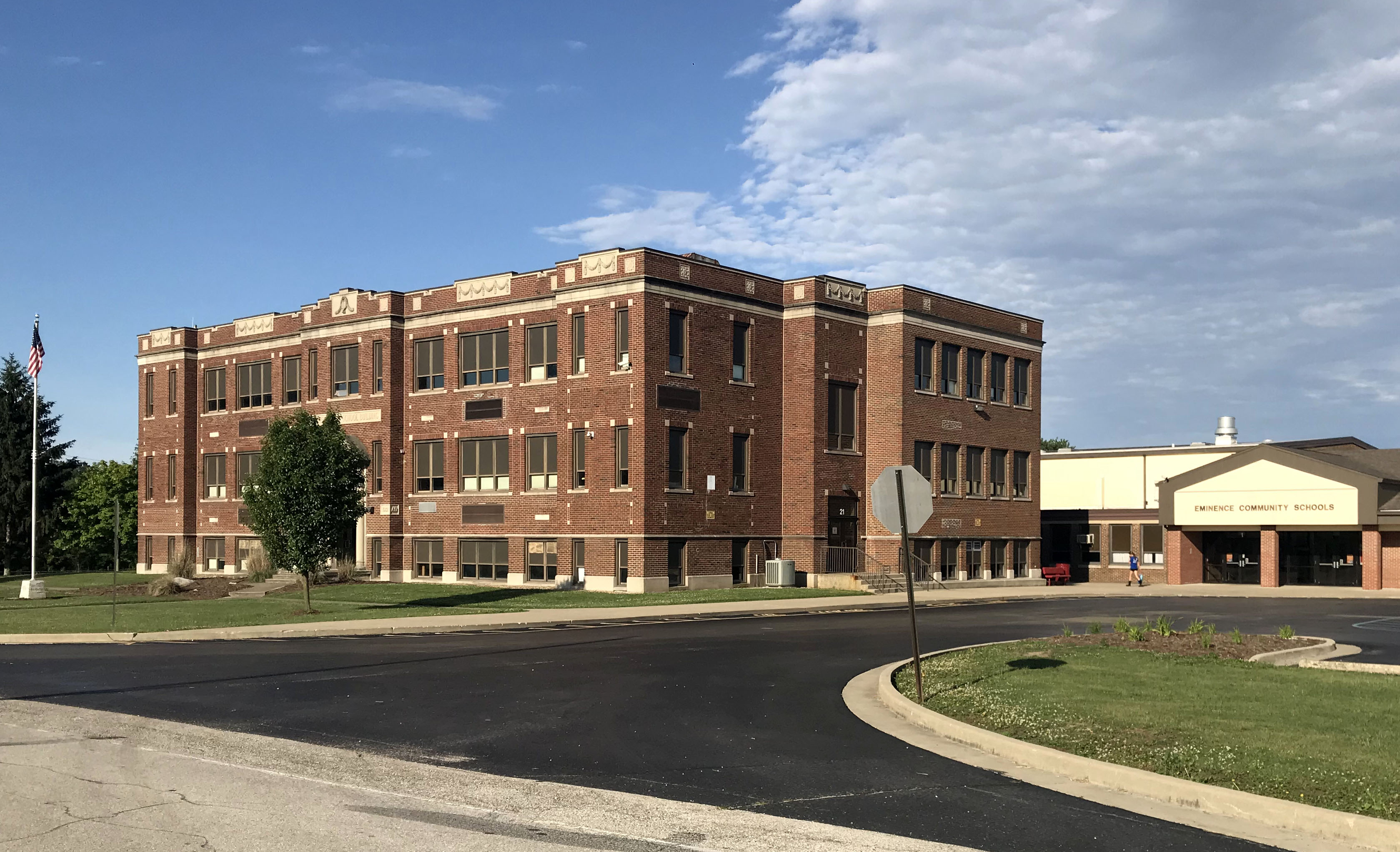 A large brick building stands prominently beside an expansive parking lot, showcasing its architectural features.