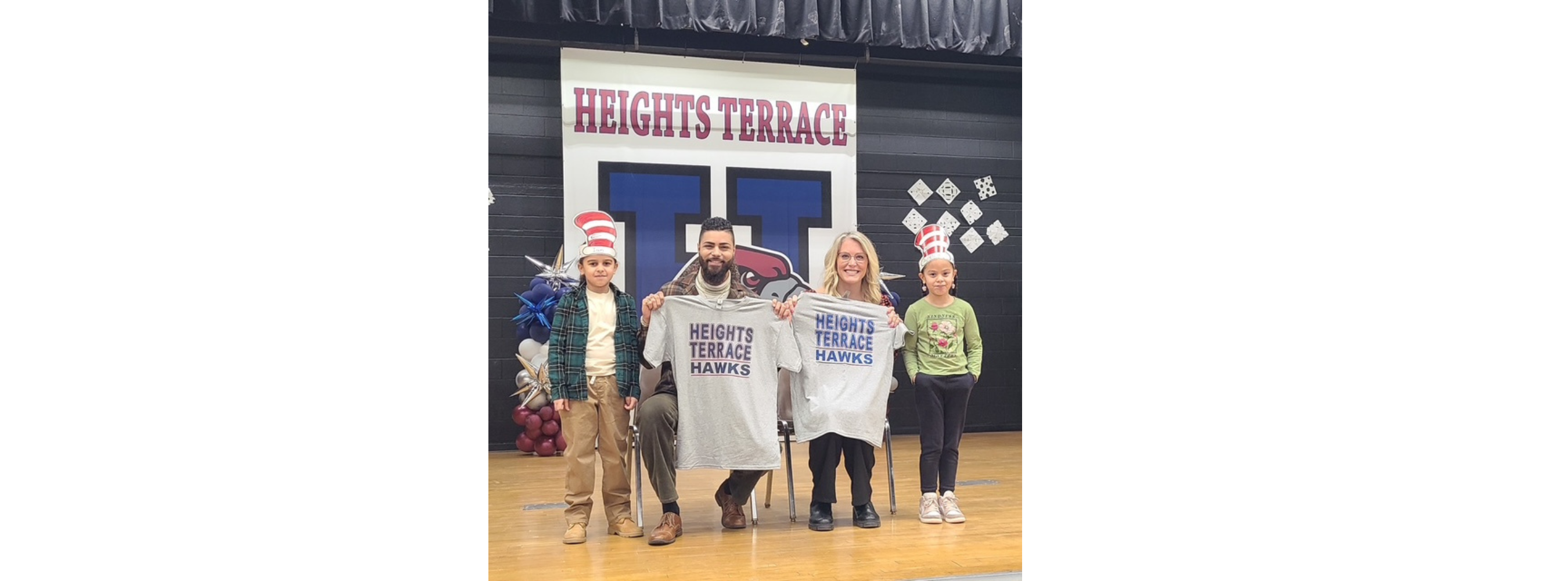 students in gym with news reporters posing for a picture