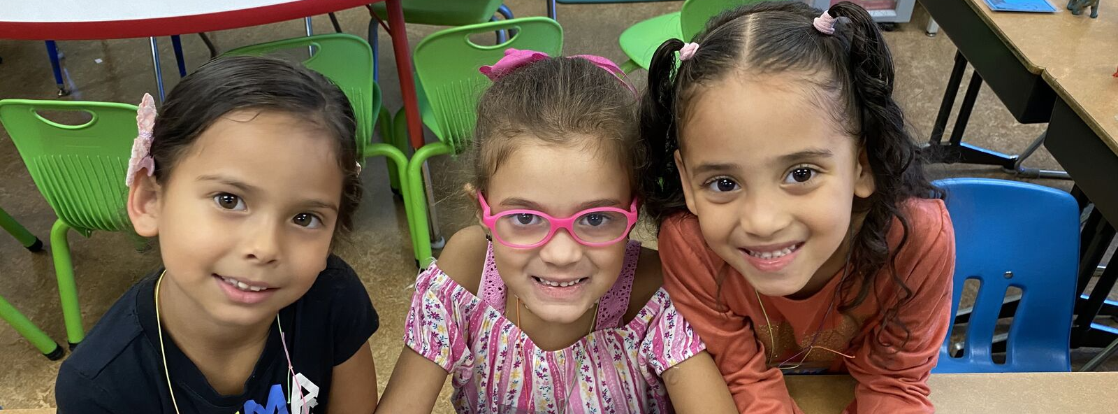 three stdents posing for a picture while coloring 