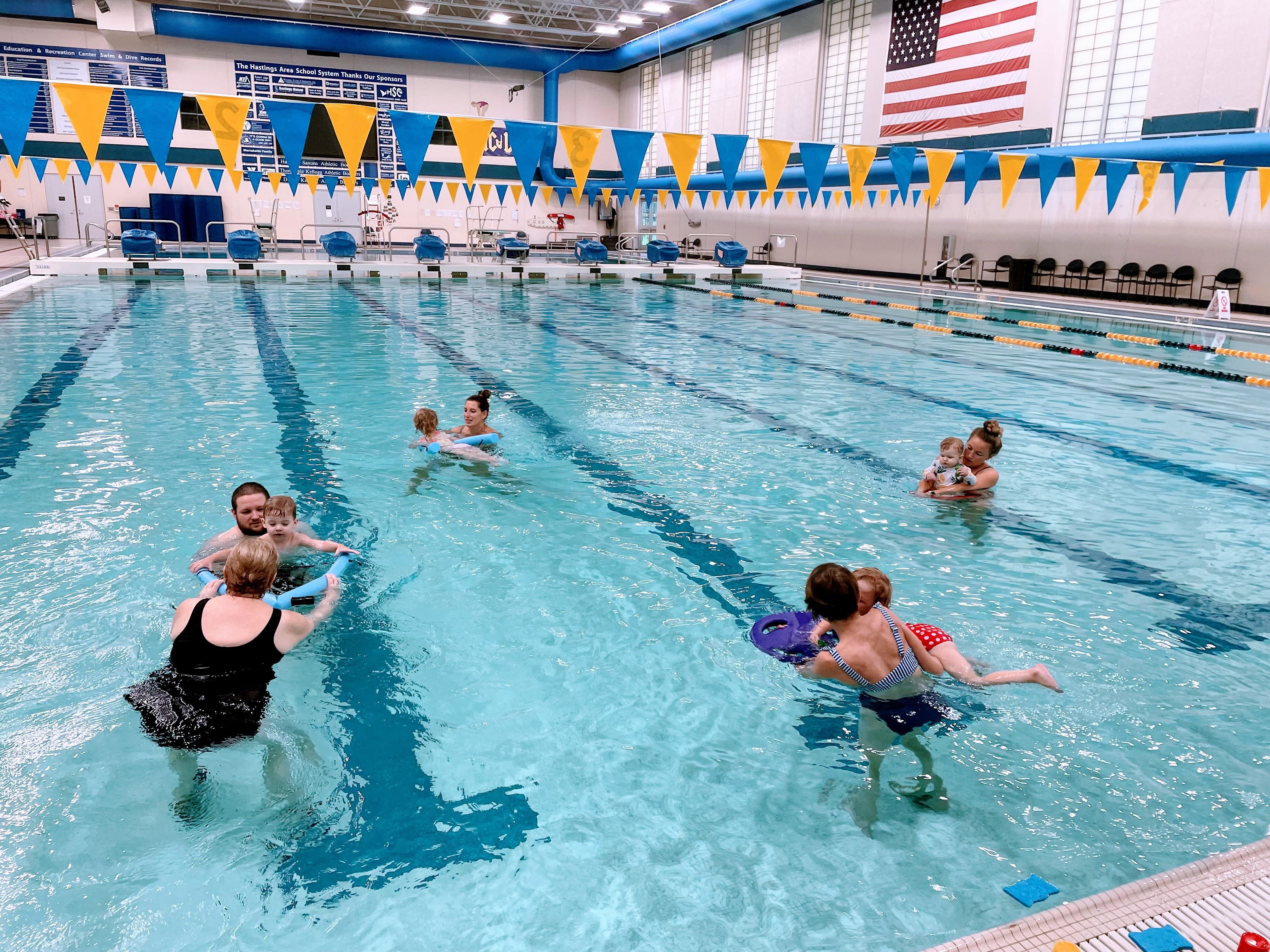 A diverse group of individuals enjoying leisure time together in a vibrant swimming pool under sunny skies.