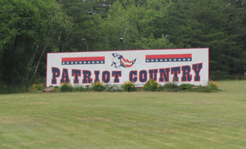 A large sign displaying the words "Patriot Country" in bold letters against a clear sky background.