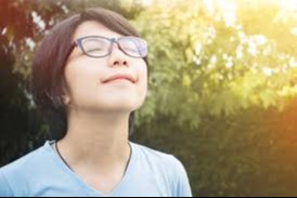 girl outside with eyes closed breathing