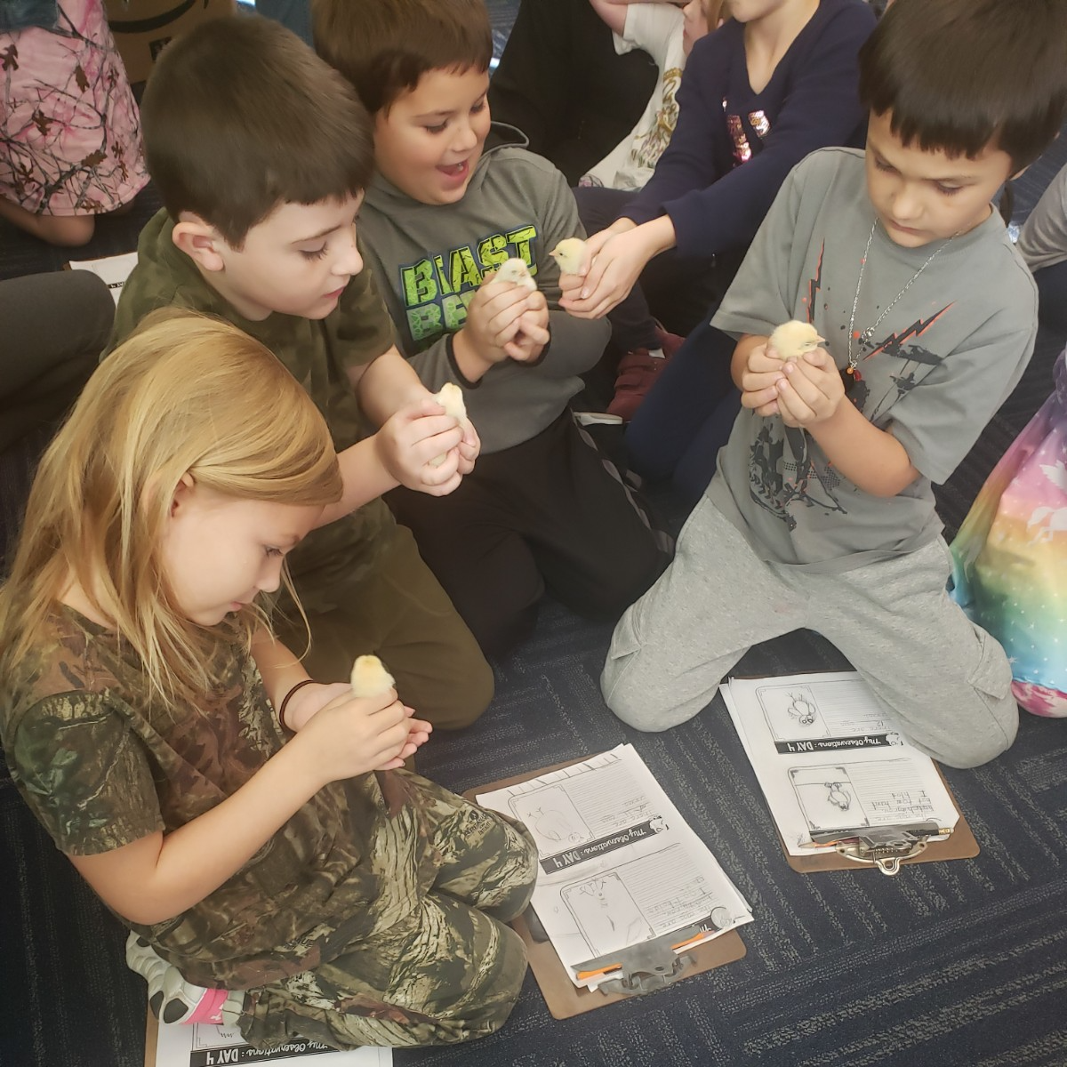 A diverse group of children sitting on the floor, engaged in play and conversation, showcasing joy and camaraderie.
