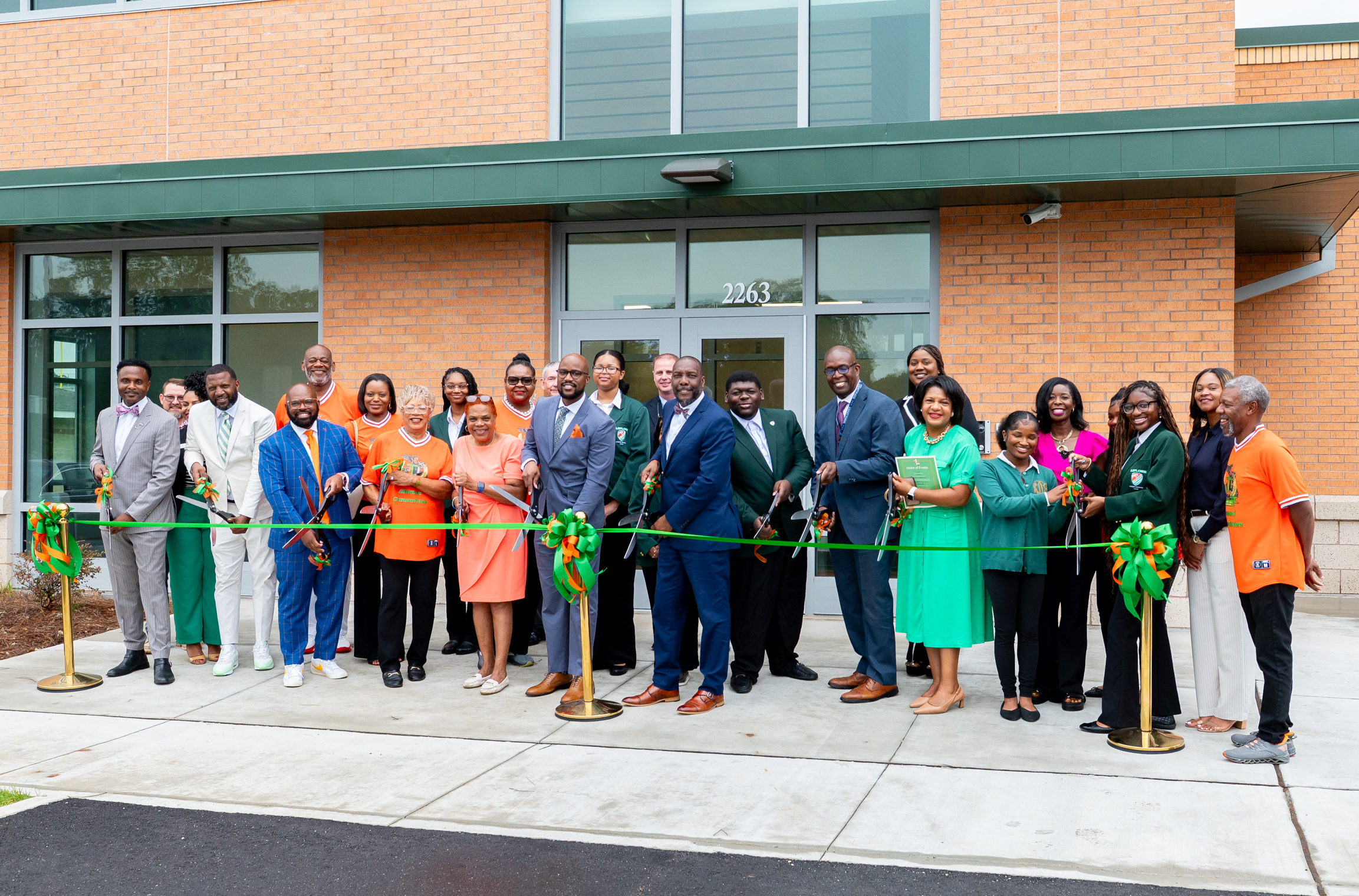 group of people cutting a ribbon for the grand opening of the new Leflore High School building