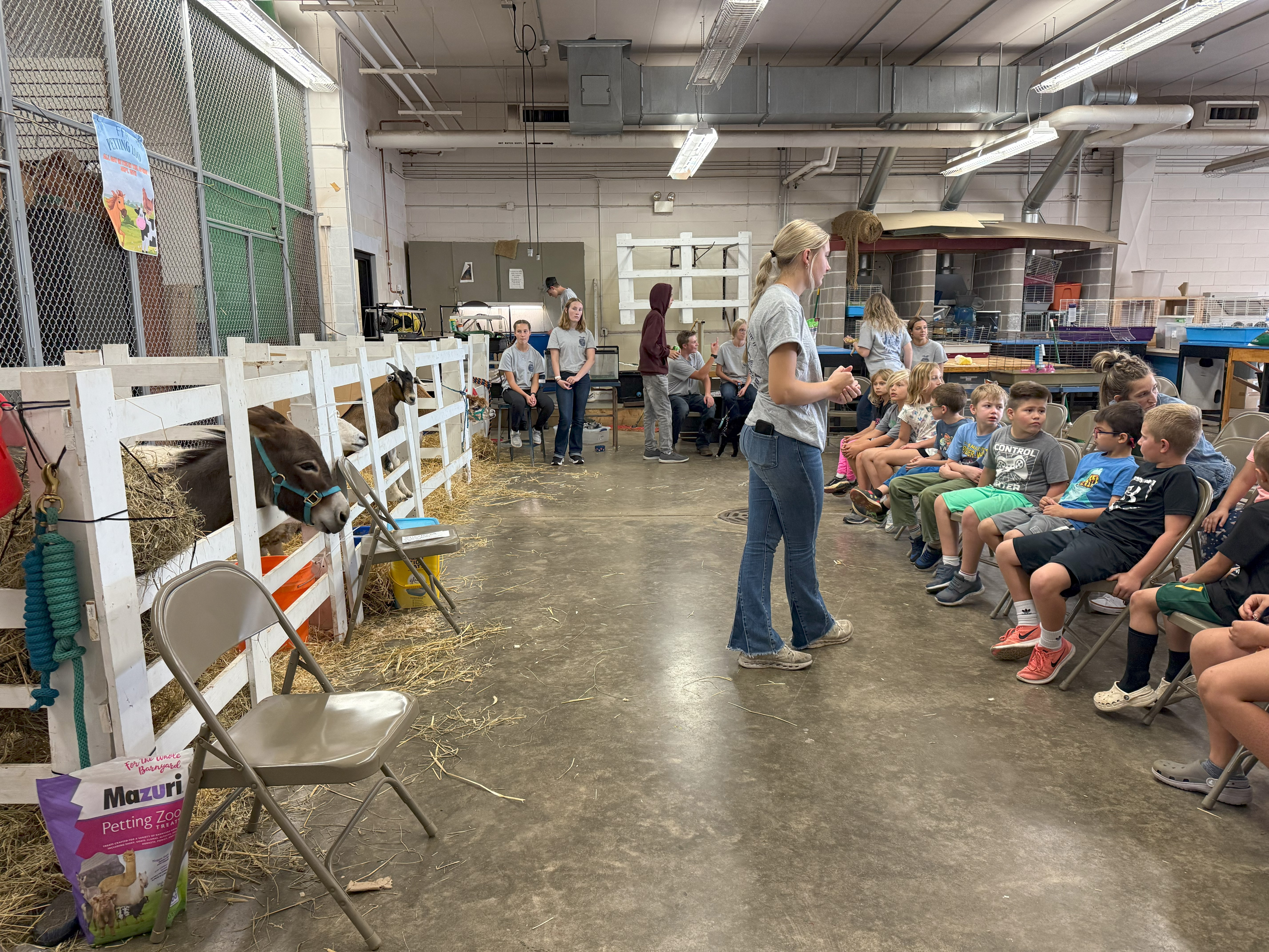High School student addresses grade school class at a petting zoo.