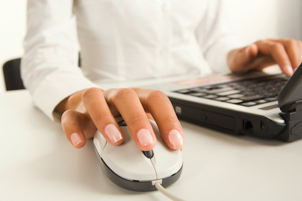 A woman's hands typing on a laptop computer, showcasing engagement with technology and productivity.