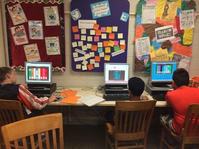Students engaged in study at the library, focused on their computers and collaborating on academic projects.