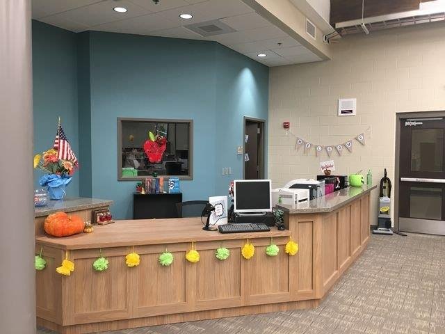 A reception area featuring a desk equipped with a computer, creating a welcoming environment for visitors.