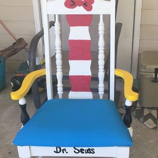 A rocking chair featuring the words "Dr. Seuss" prominently displayed on its backrest.