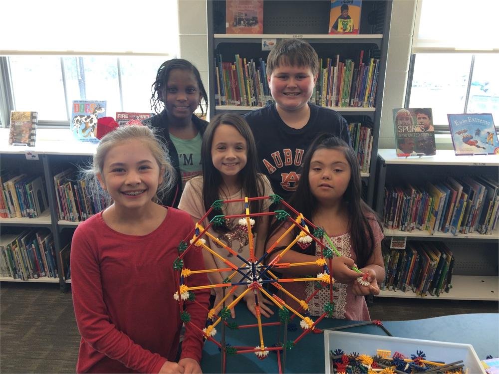 Students studying in a library, with a colorful Ferris wheel visible through the windows, creating a vibrant atmosphere.