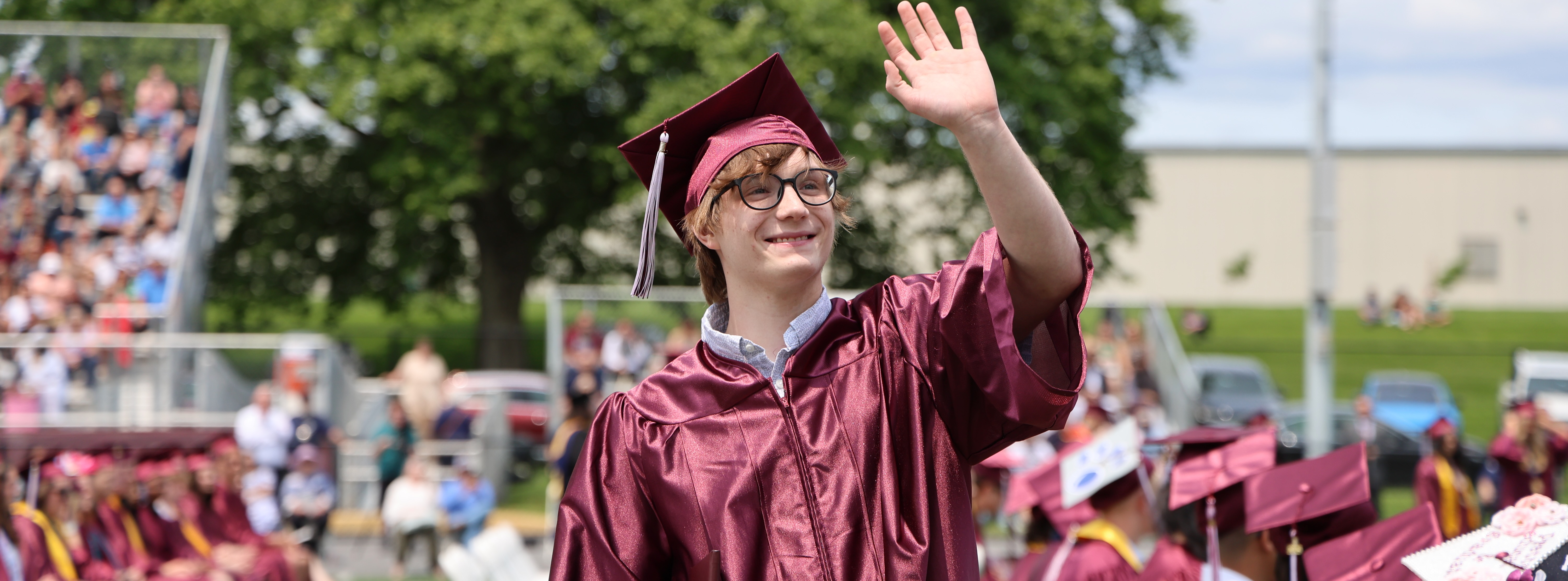 Graduate waving to crowd