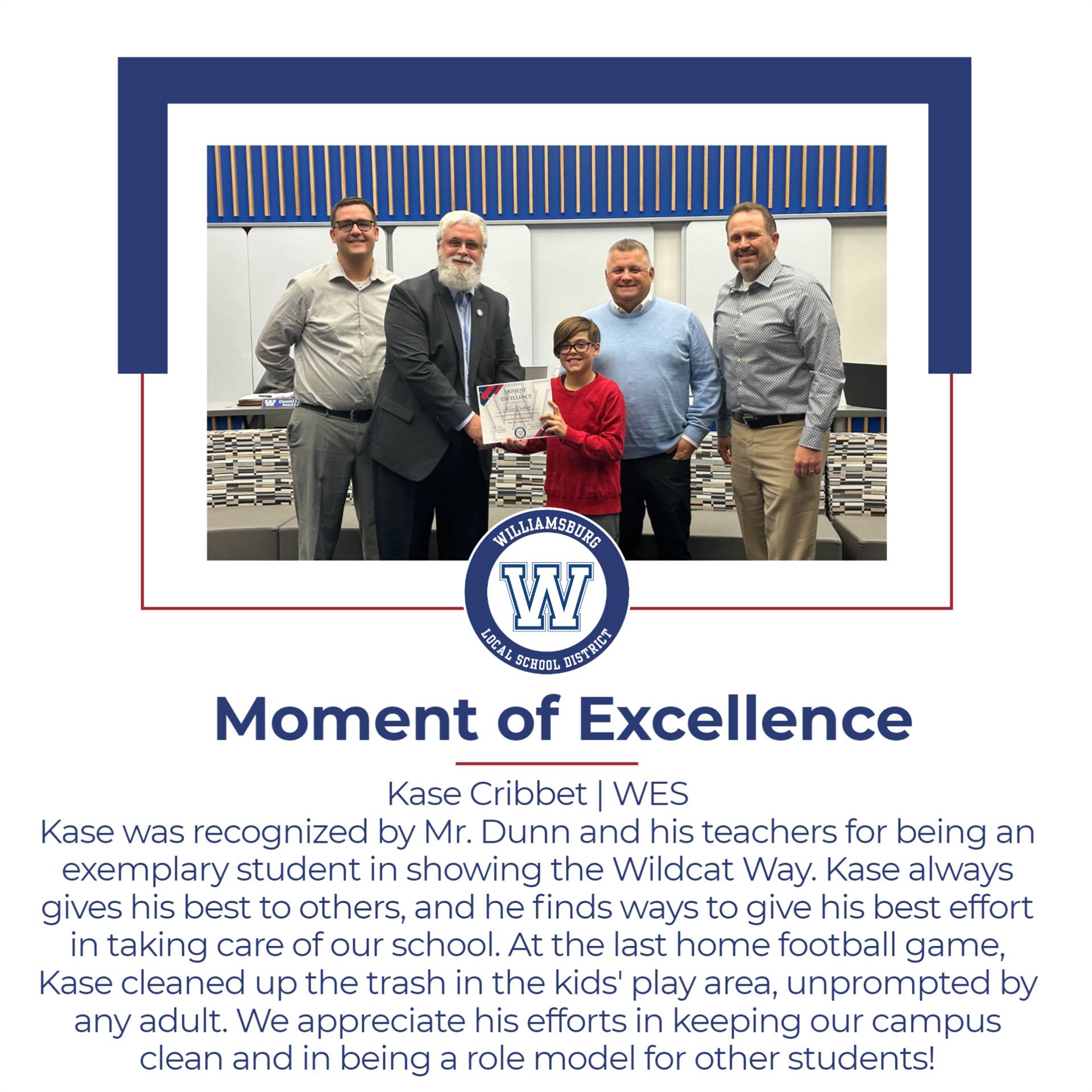 A student proudly holds an award, surrounded by teachers, celebrating exemplary behavior and community service at Williamsburg School.