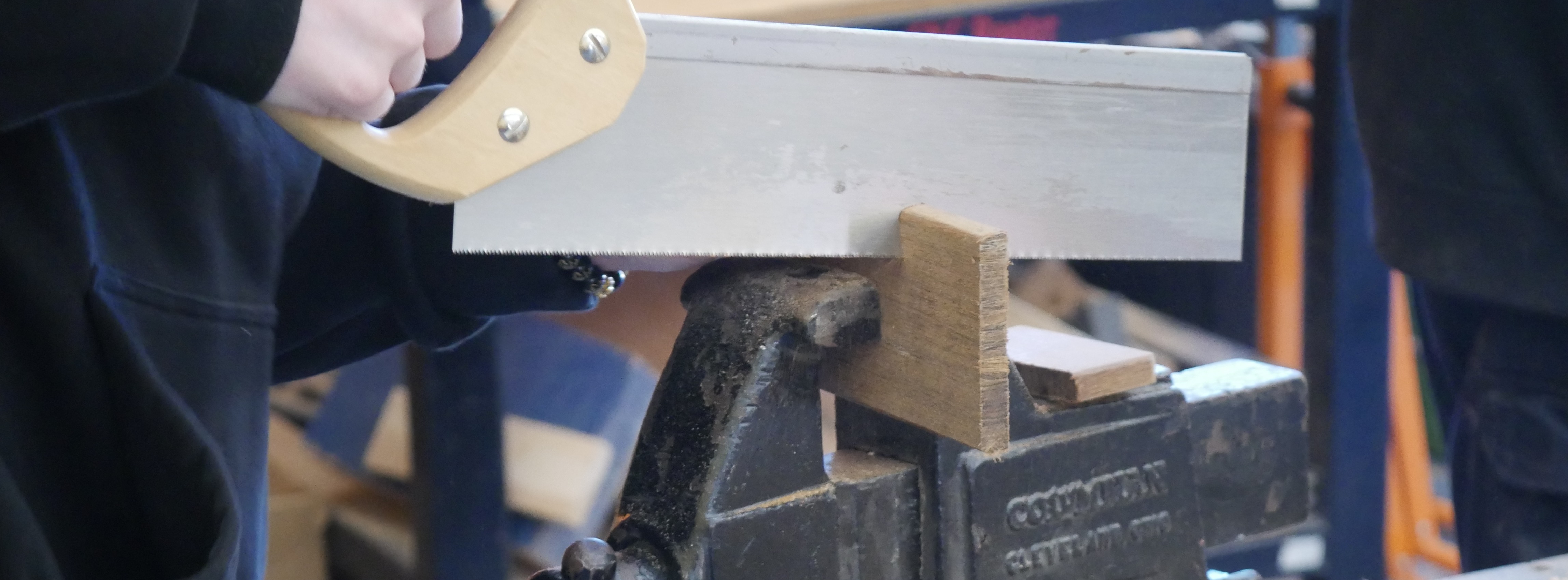 Student using a saw on a piece of wood
