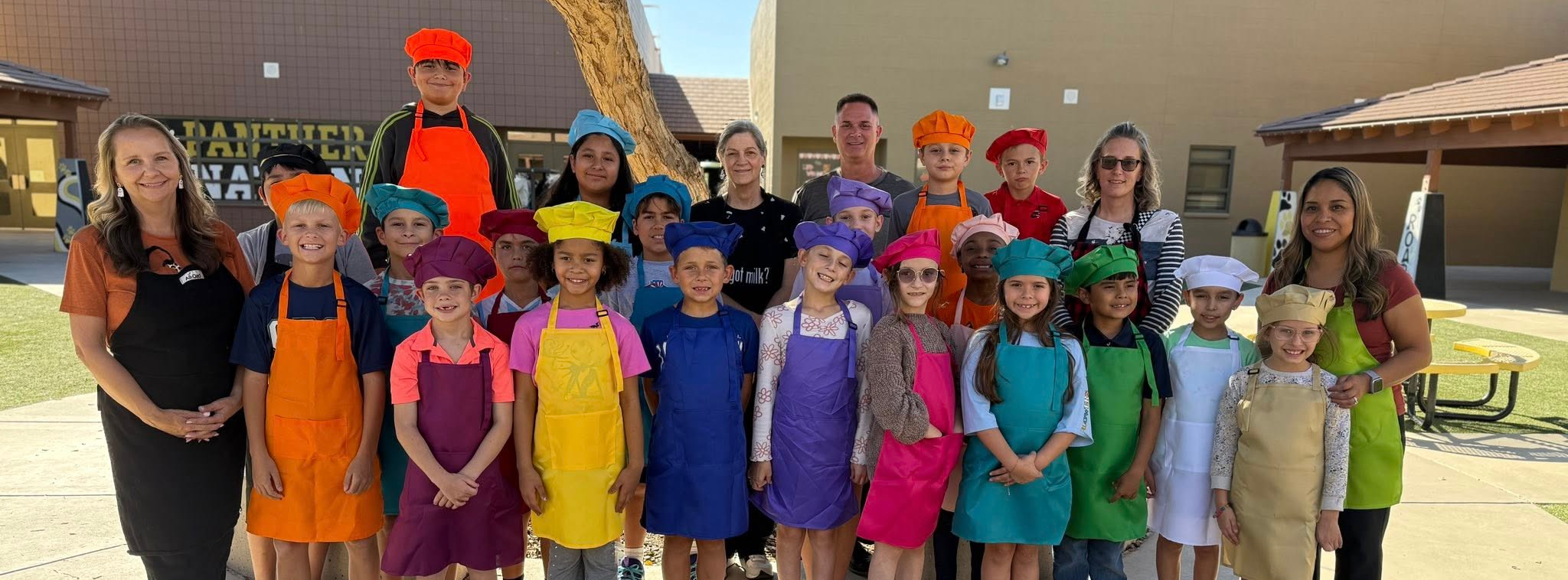 Photograph of kitchen club at Mabel Padgett courtyard in their aprons and chef hats