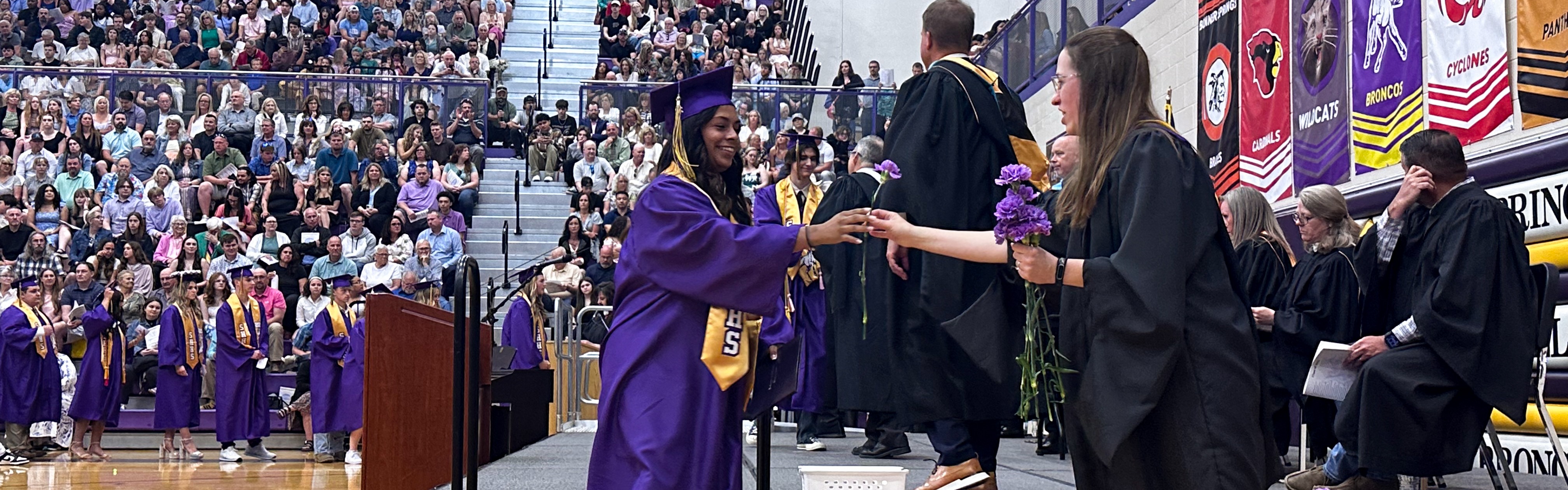 Image of students, families and staff at a graduation ceremony