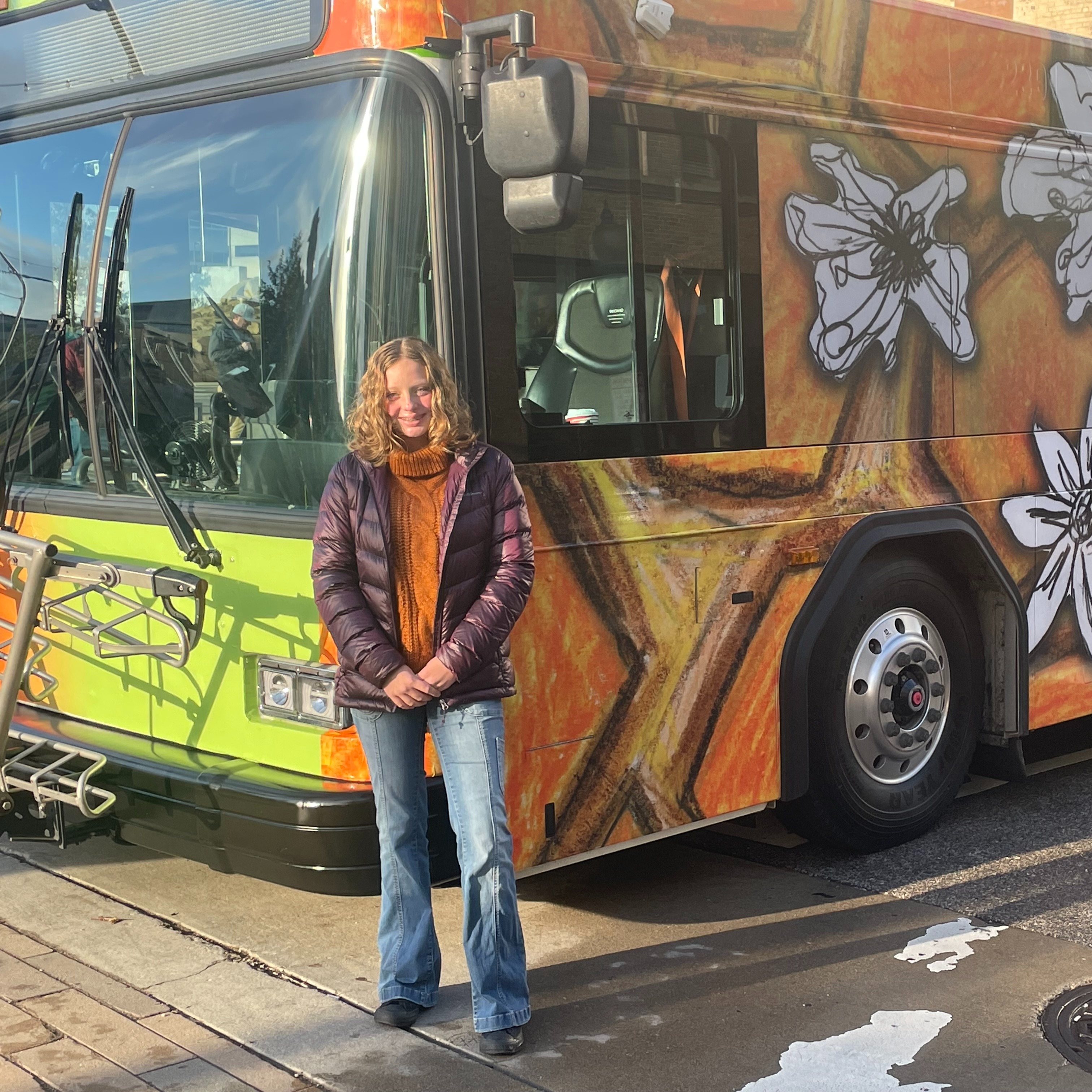 elkview middle school student standing in front of KRT bus that is displaying her design
