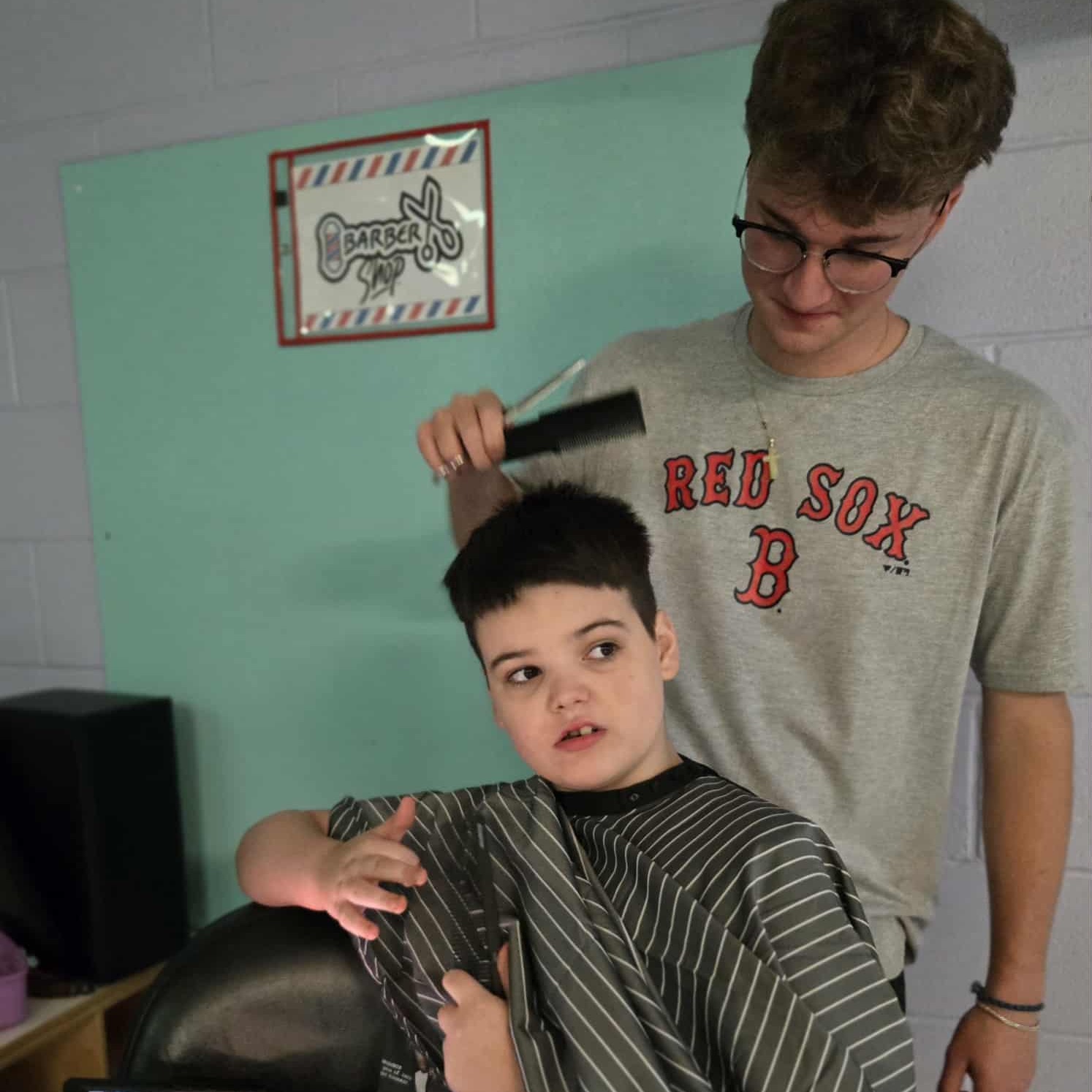 ruffner elementary student getting his haircut by a student in the barber program at carver career center. 
