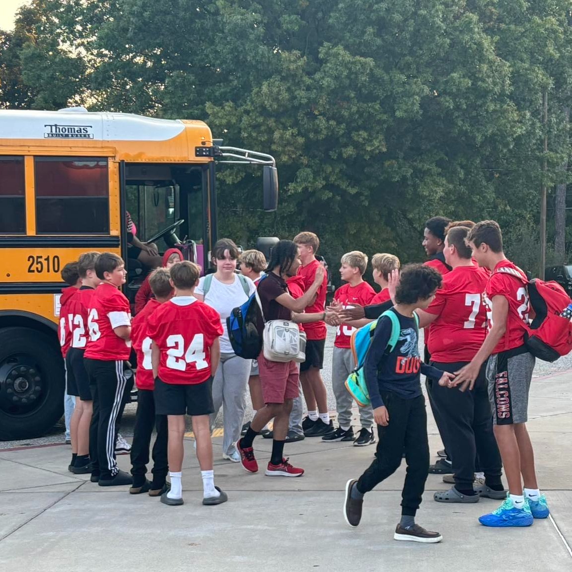 john adams middle school football team welcoming their classmates to school.