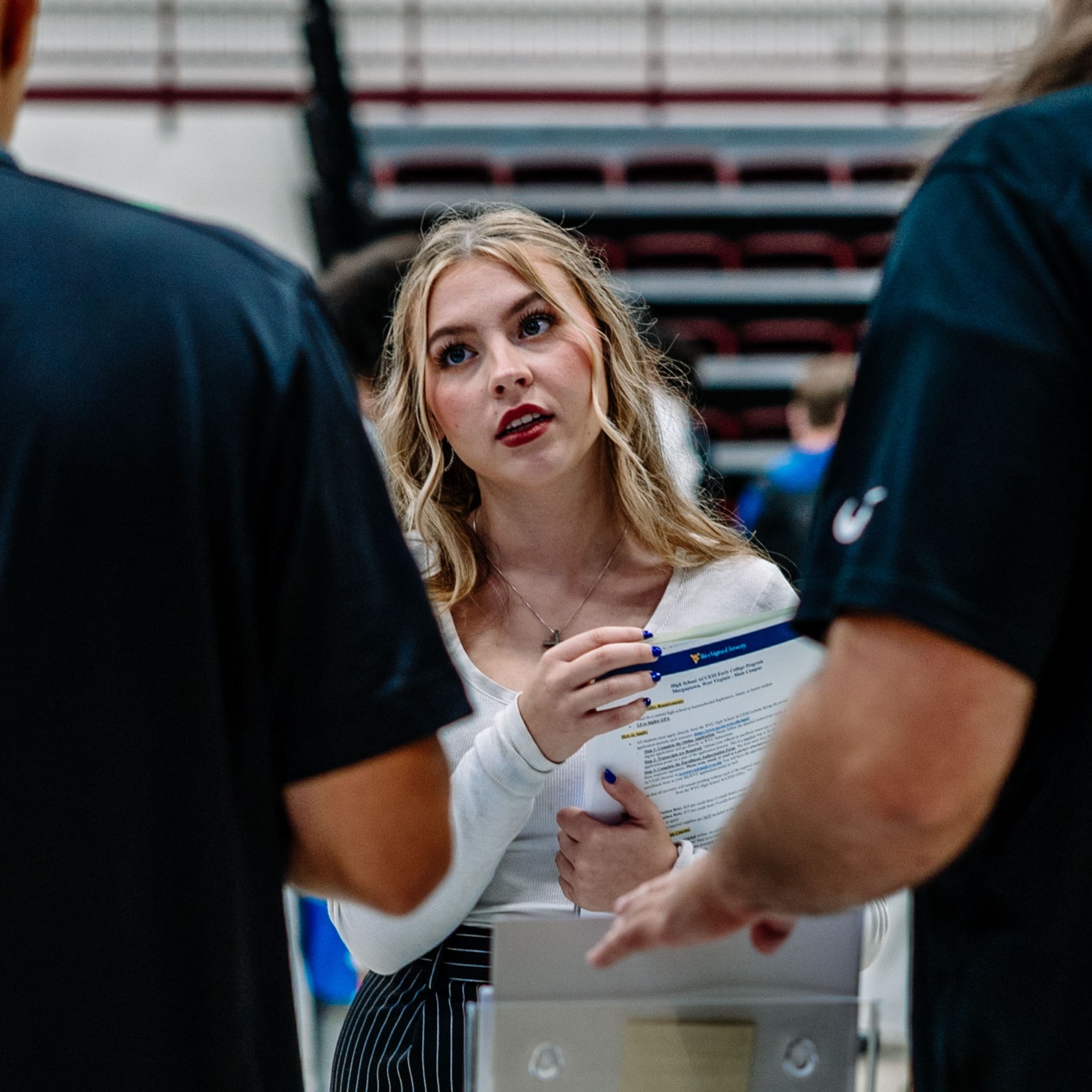high school student speaking with marshall university reps during a college fair.