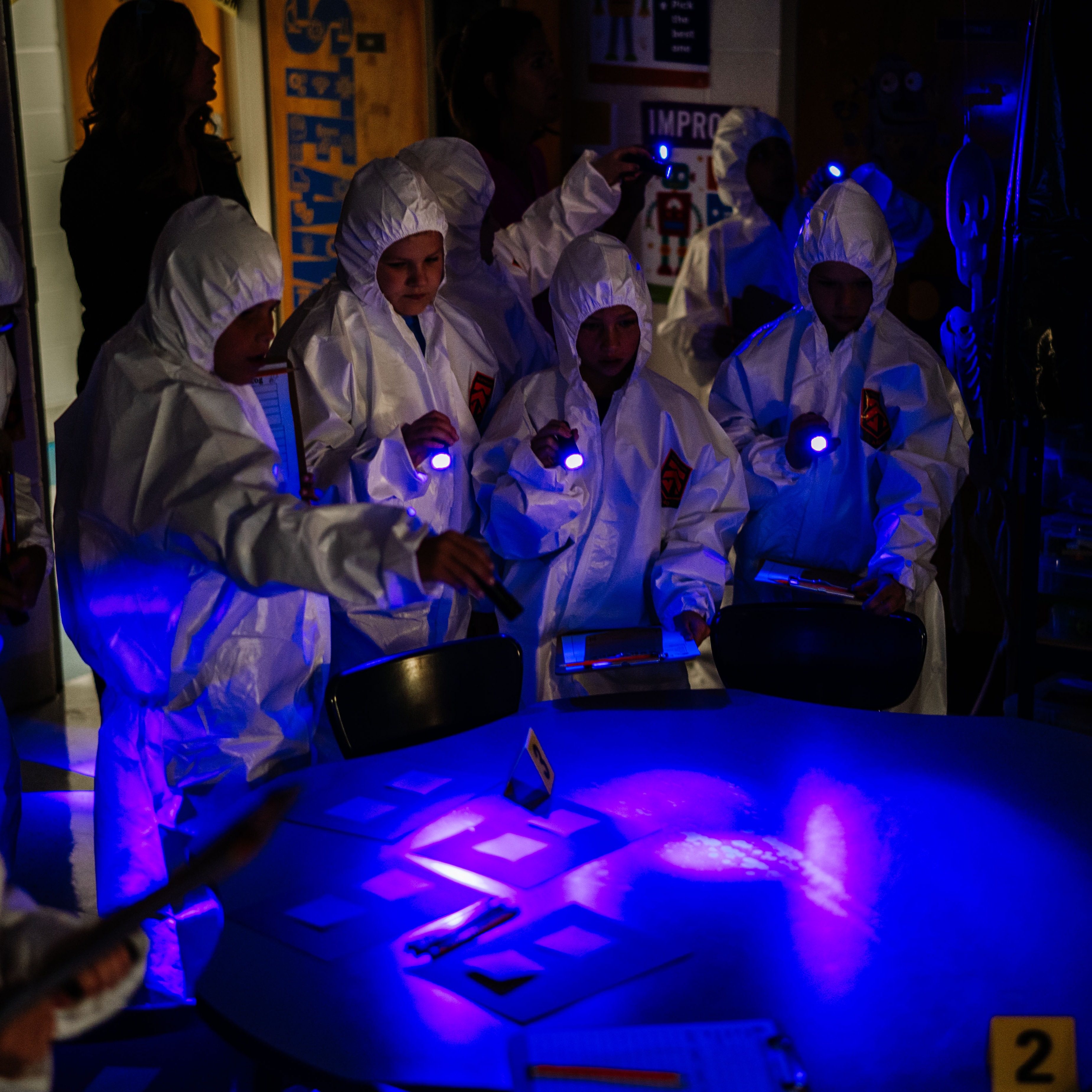 cross lanes elementary students using black lights during a forensics lesson.