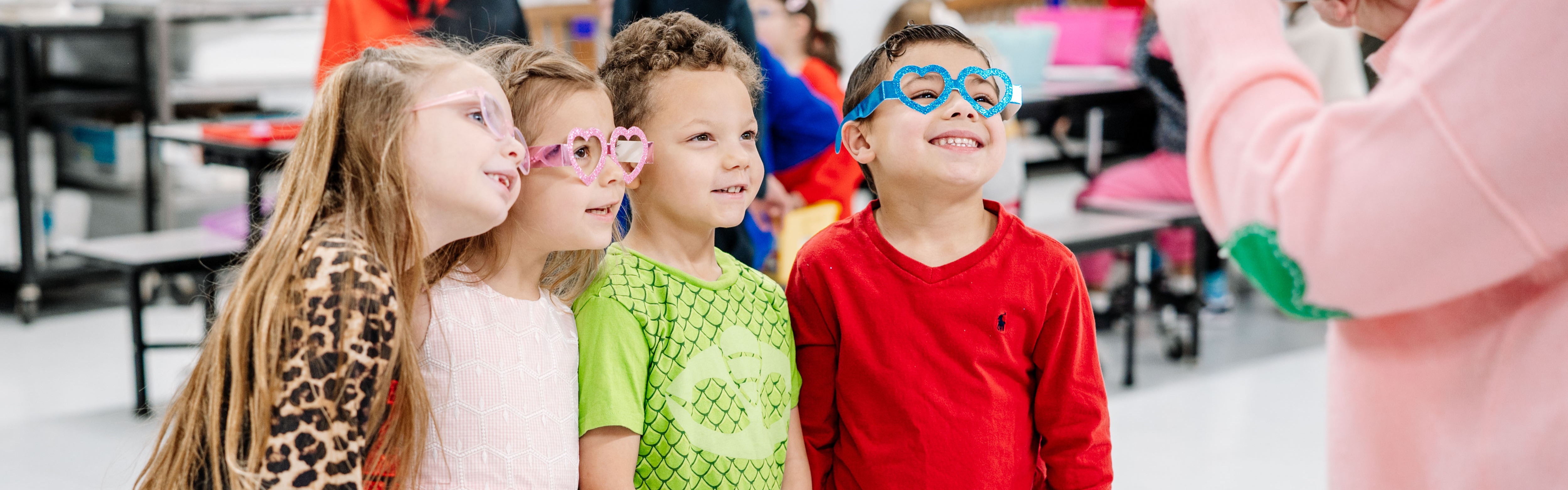 Four students are standing together in the school cafeteria posing for a picture.