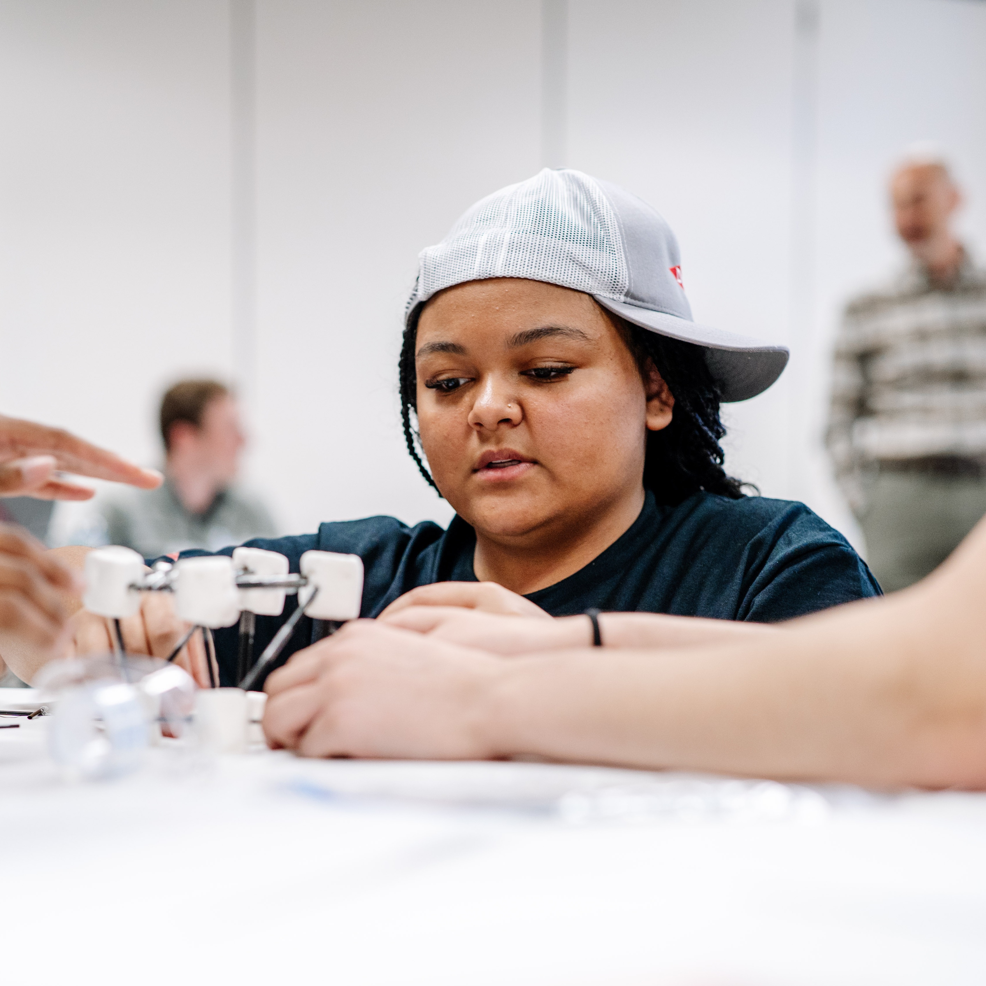 A student is working on building a model bridge during the DOW Leadership Academy. 