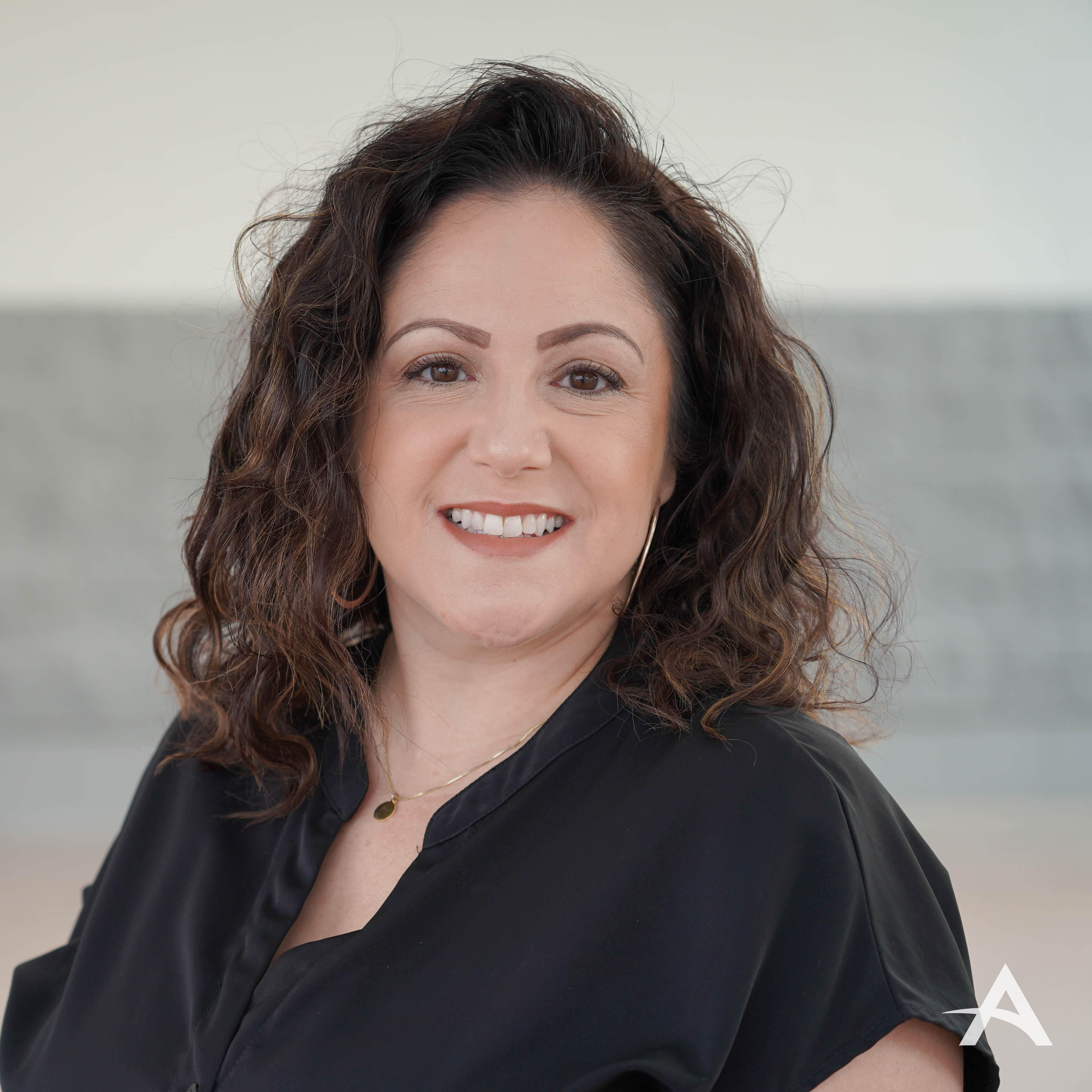 Smiling woman with curly dark hair in black top