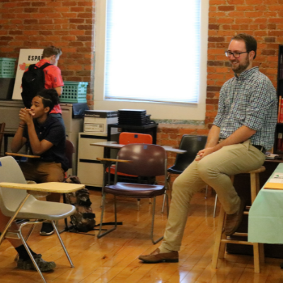 Teacher smiles as he engages with students