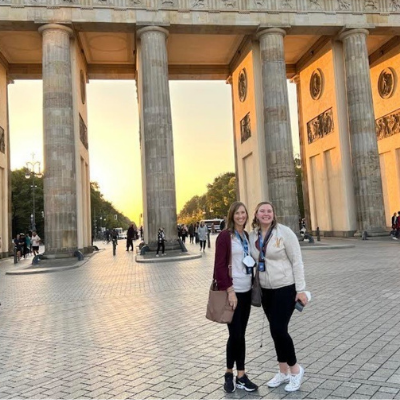 Two teachers stand before a row of columns in germany