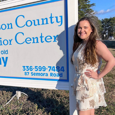 Alex stands in front of the person county senior center sign