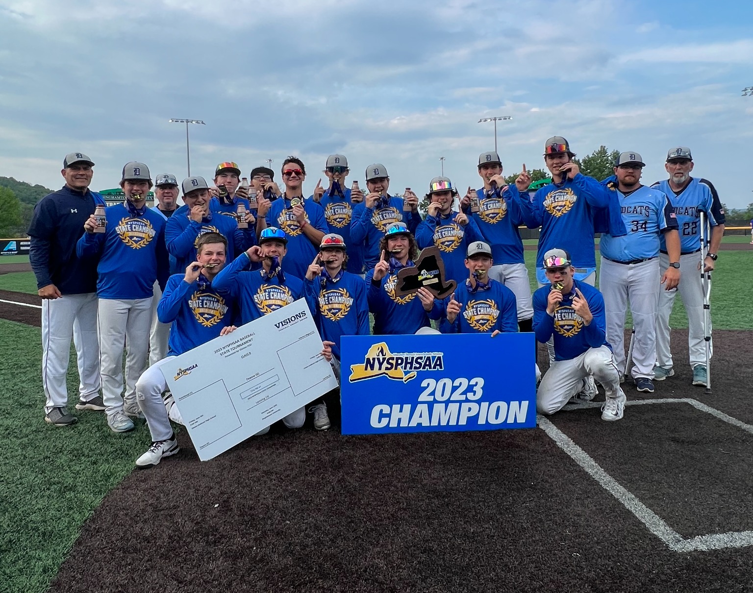 Baseball team pose with state championship sign