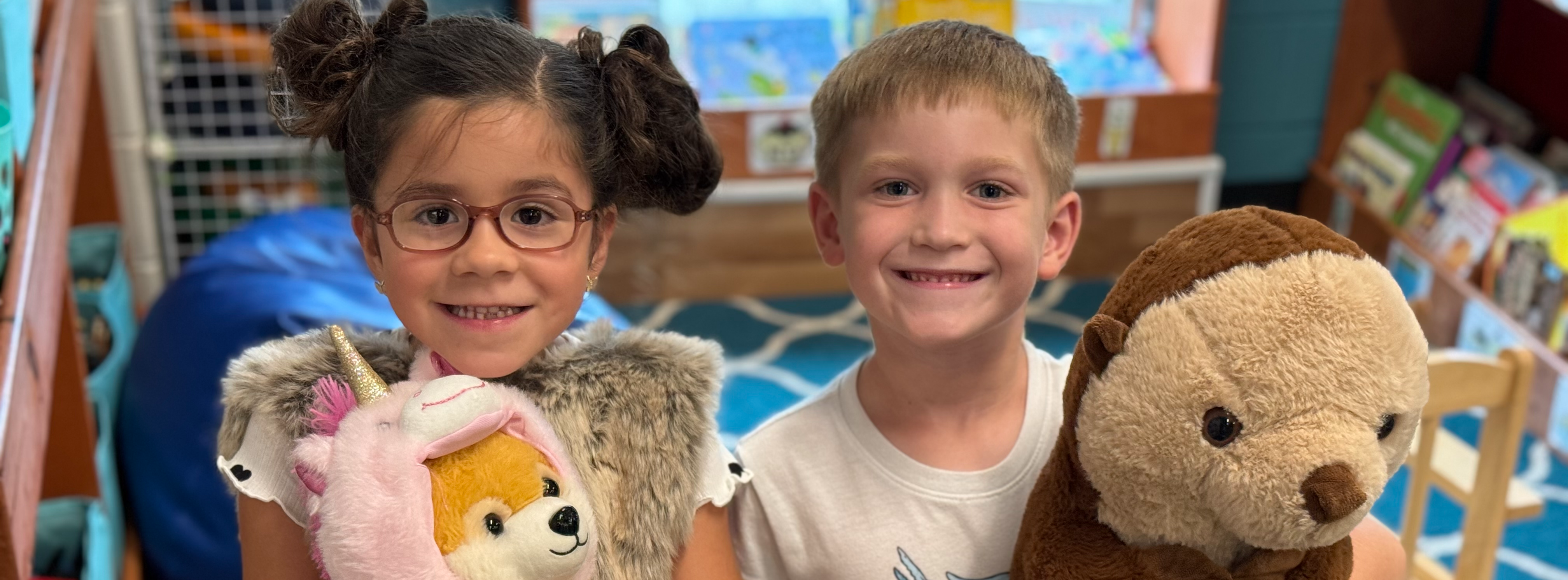 Little students holding stuffed animals.