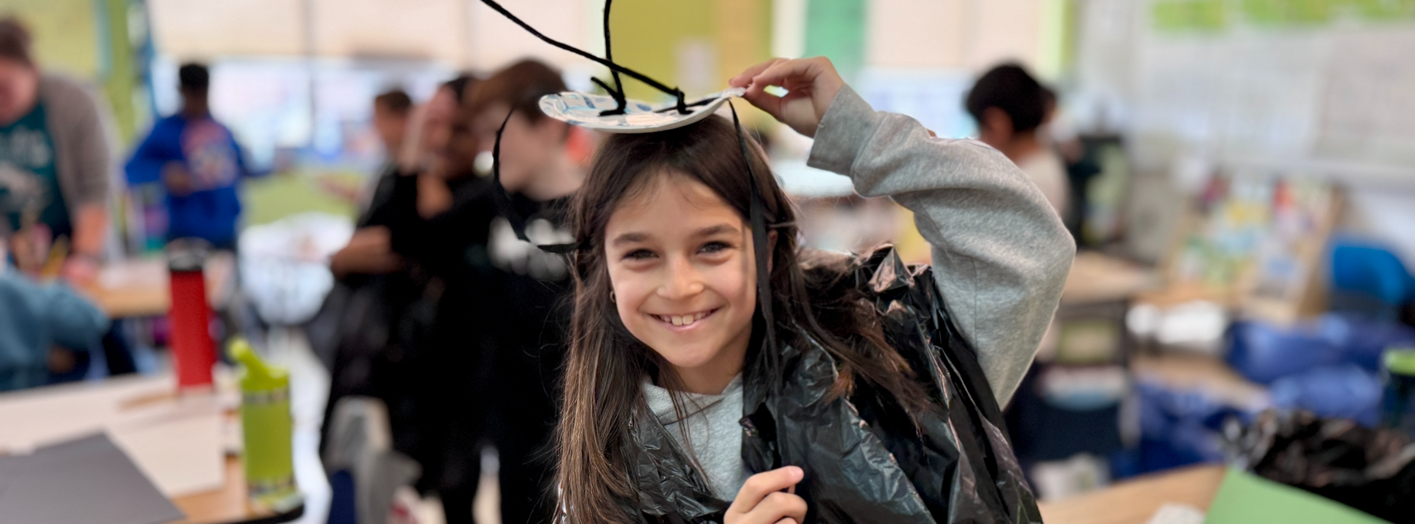 Student in classroom dressed in insect costume.