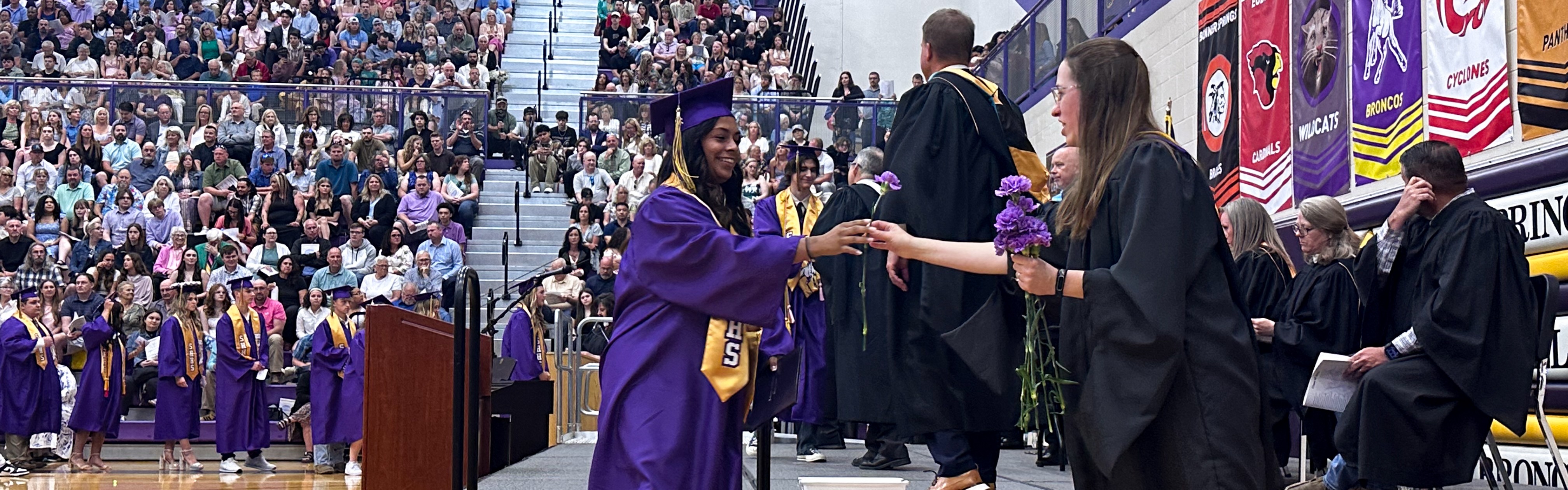 Image of students, families and staff at a graduation ceremony