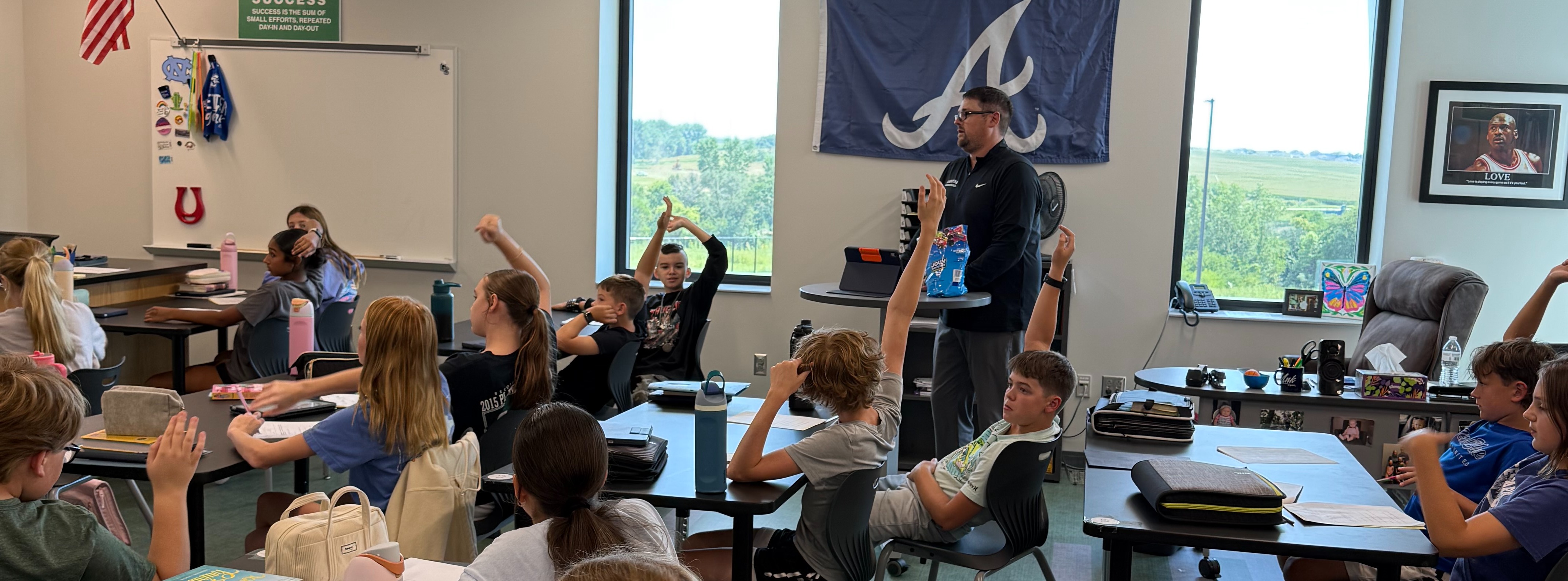 students raising their hand to answer a question in a science classroom taught by Mr. Stotz
