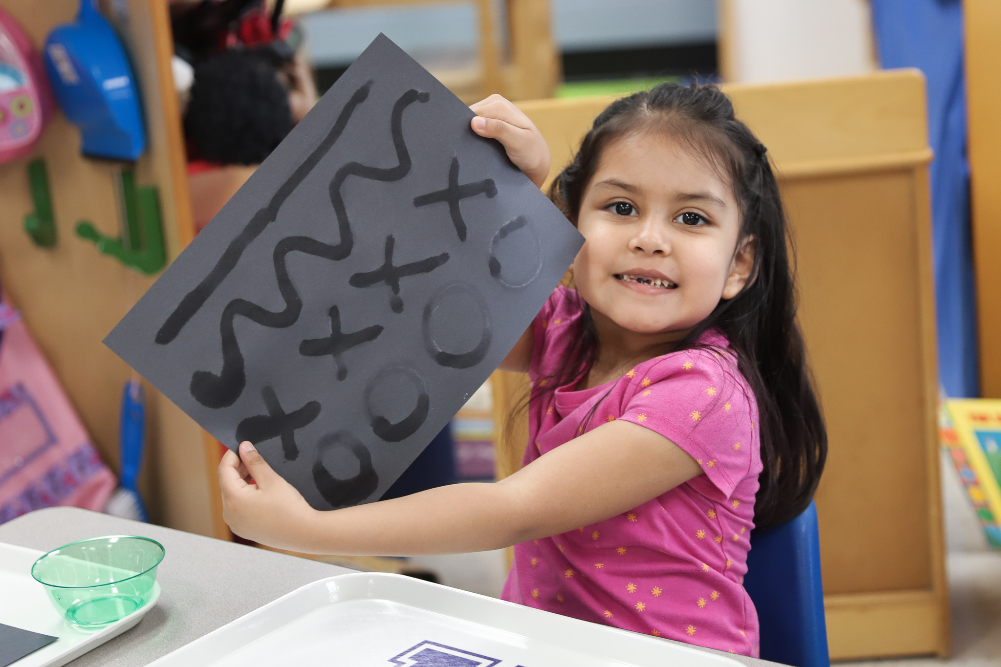 Student showing art created with brush and water