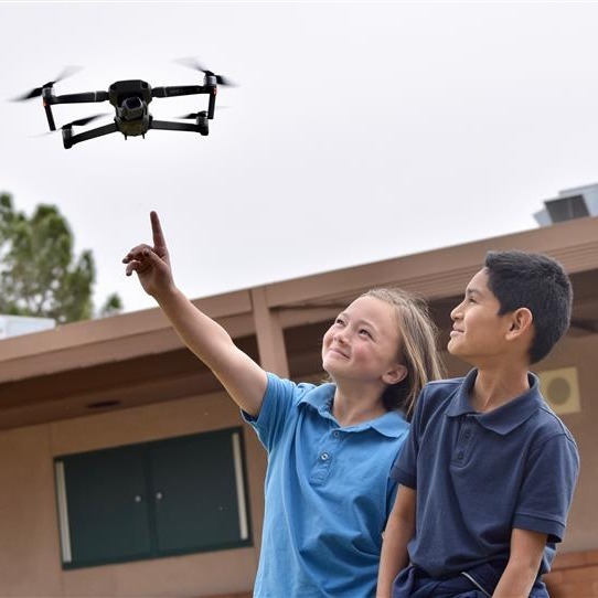 kids looking at drone
