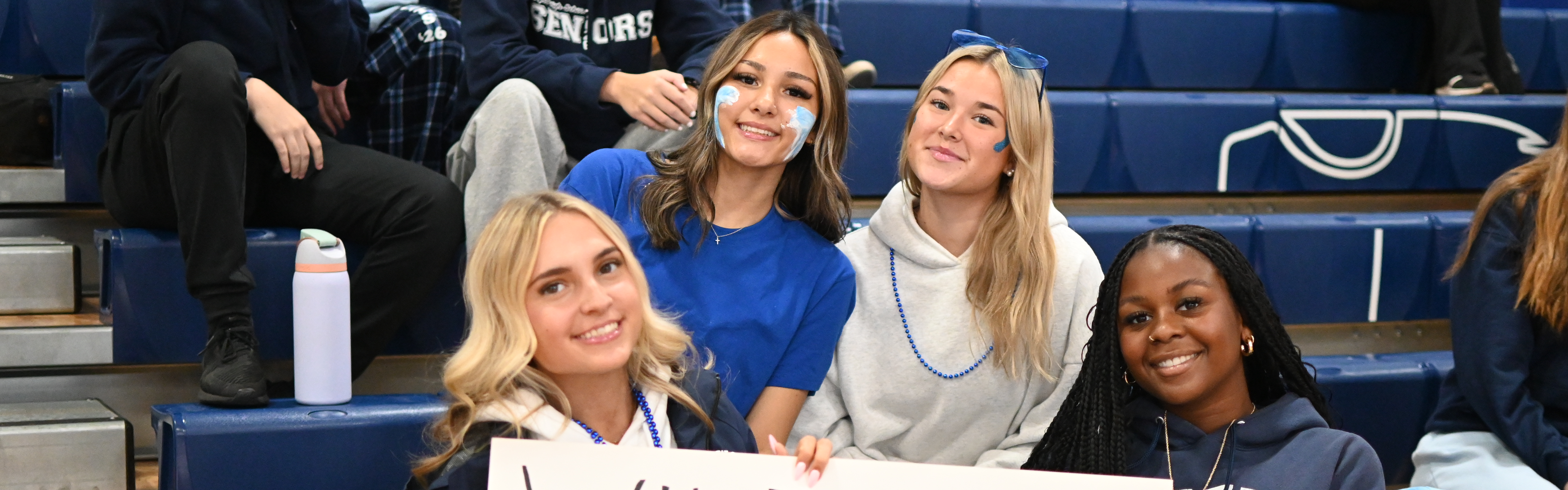 students pose with wildcats are best sign