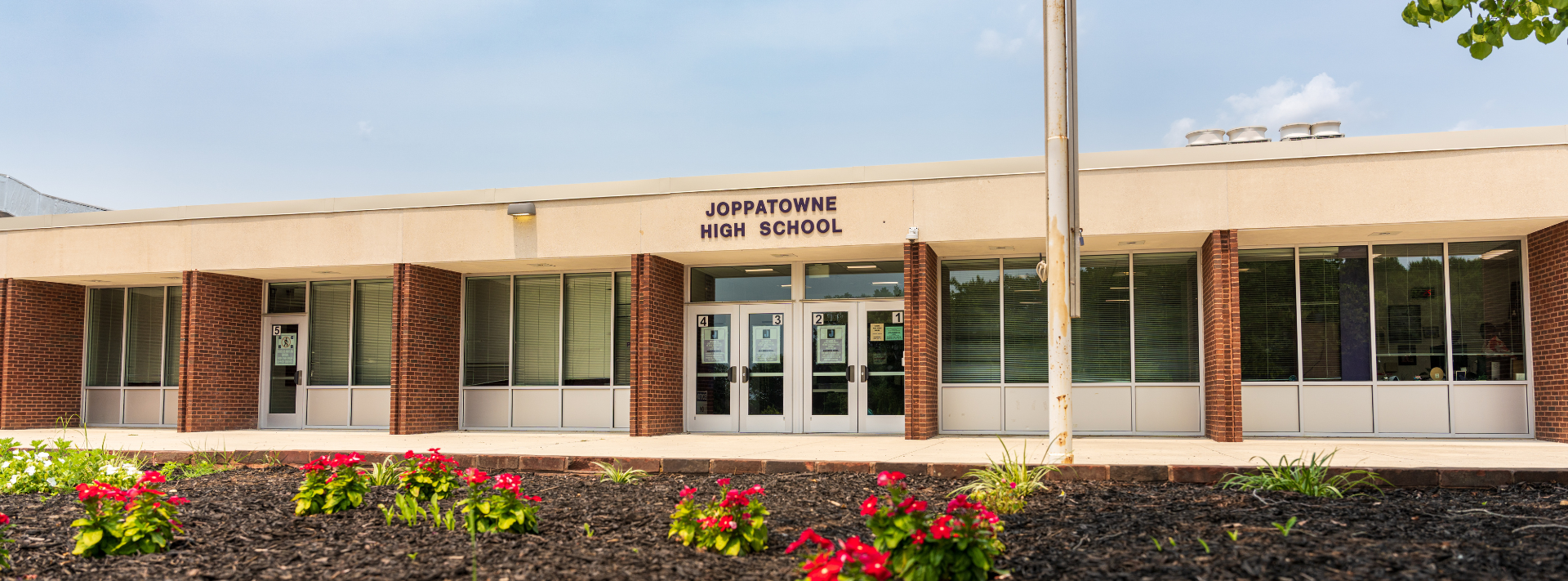 Photo of the main entrance of the school building with "Joppatowne High School" signage.