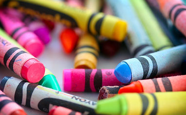 A close-up view of various colorful crayons scattered on a surface, showcasing their vibrant hues and textures.