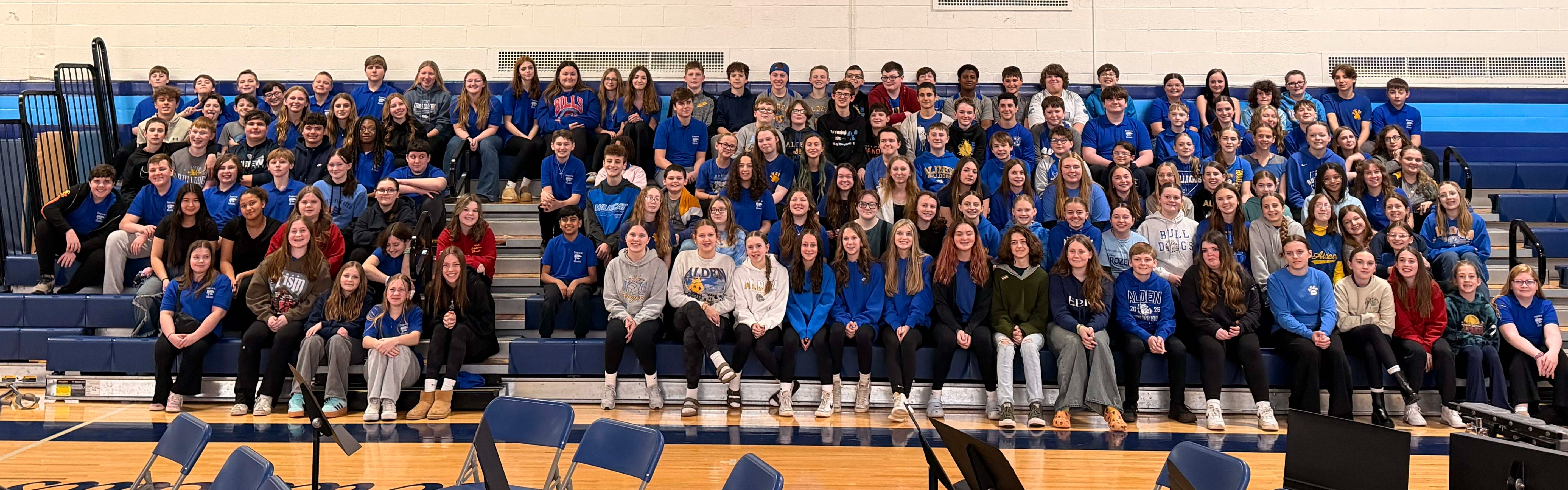 dms band sits in bleachers of gym for picture