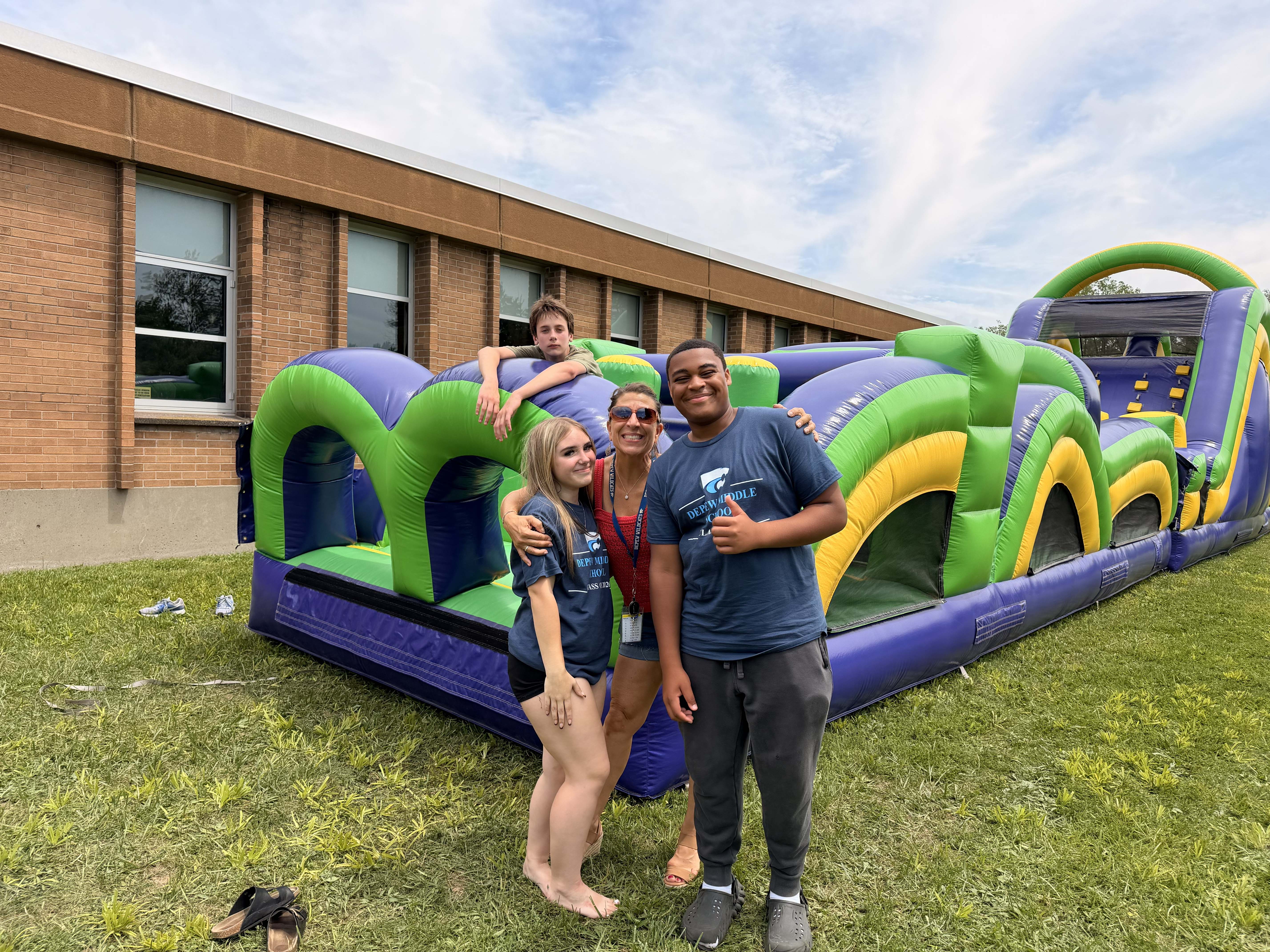 students pose in front of inflatable obstacle course
