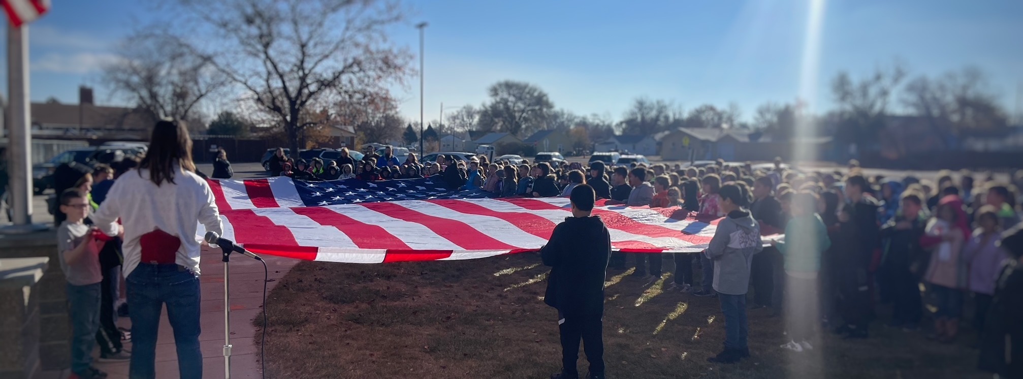 students holding  giant USA flag