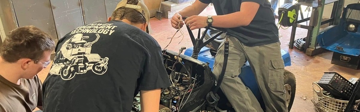 High school Students working on a piece of wired mechanical equipment